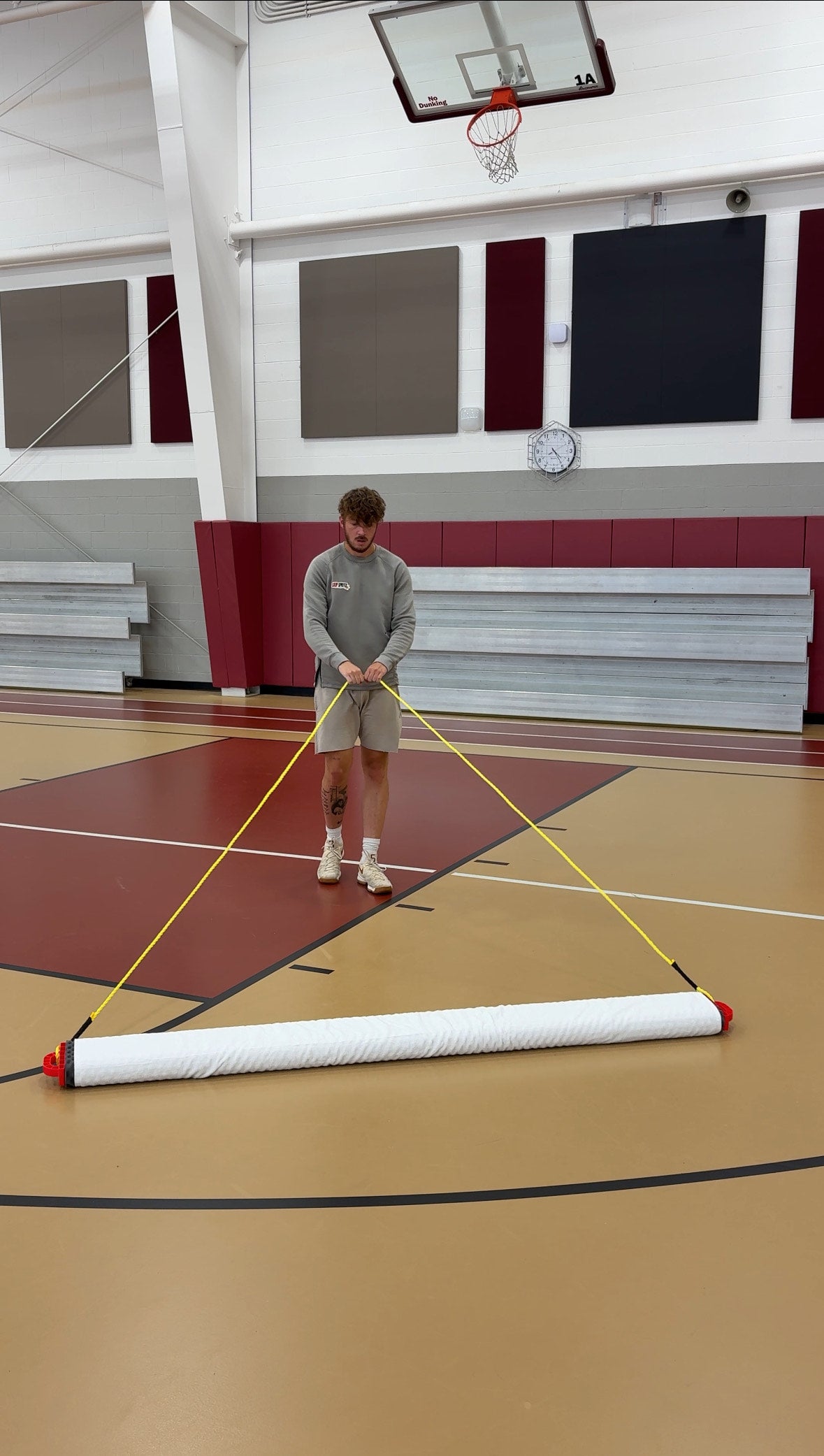 Person cleaning a basketball court with the grip spritz wet mop system